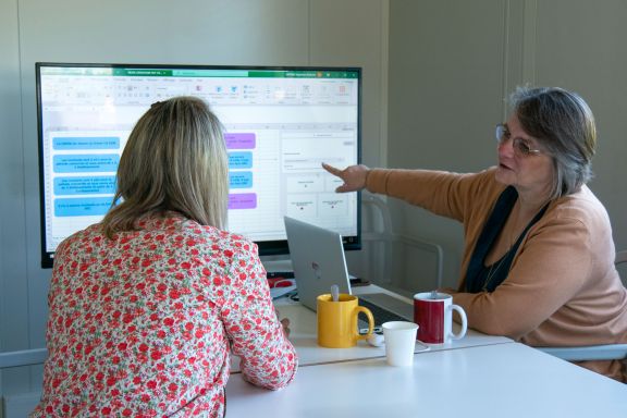 Photo de membres équipe O3 Experts en discussion et échange devant un ordinateur